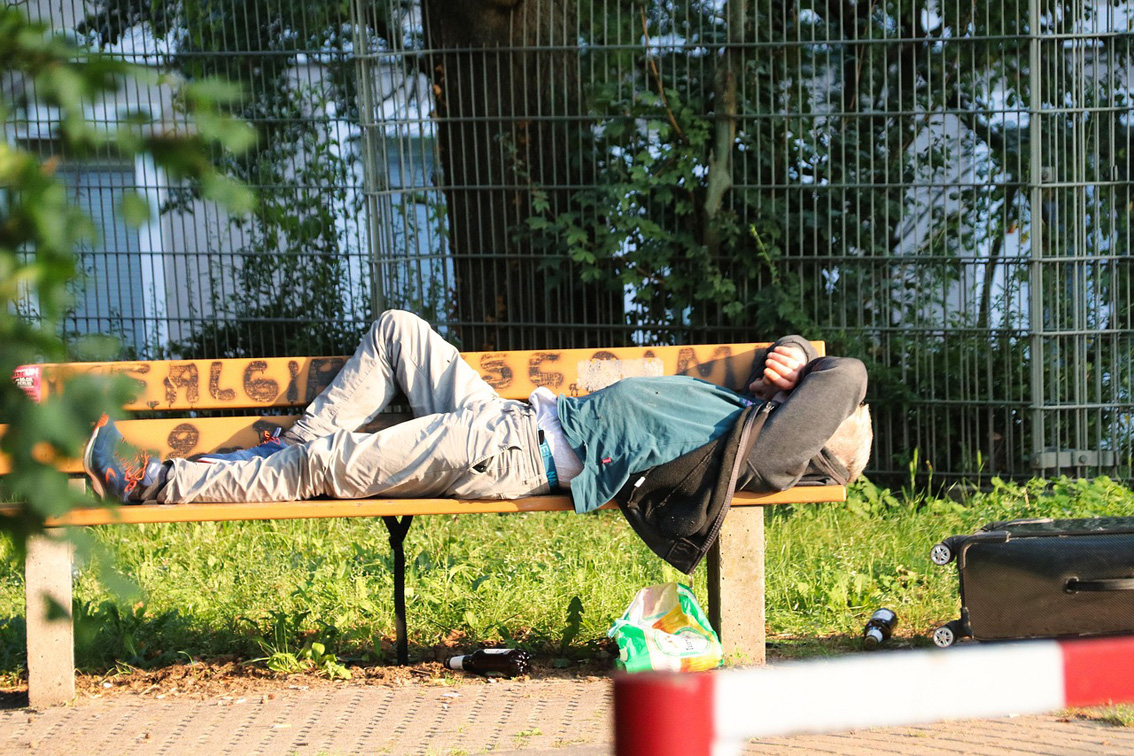 Un sans-abri dort sur un banc dans un parc